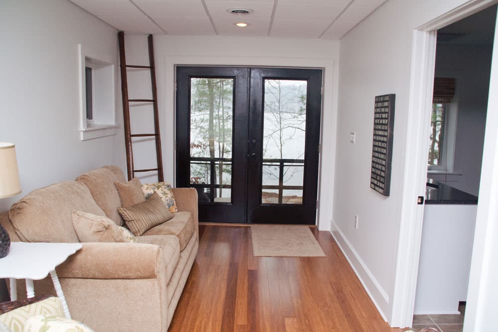 Finished basement with black French doors leading to walkout patio