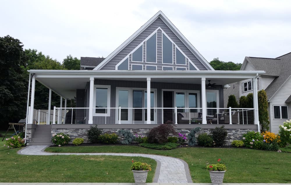 Gray craftsman-style house with white trim, large windows, and covered porch with cable railings