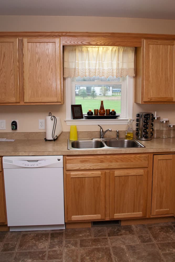 Kitchen featuring oak cabinets, double stainless steel sink, and window overlooking lawn