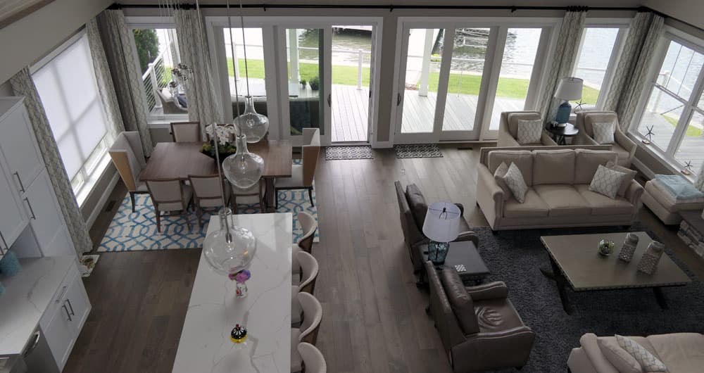 Open-concept great room with dining area, living space, and lakefront view through glass doors