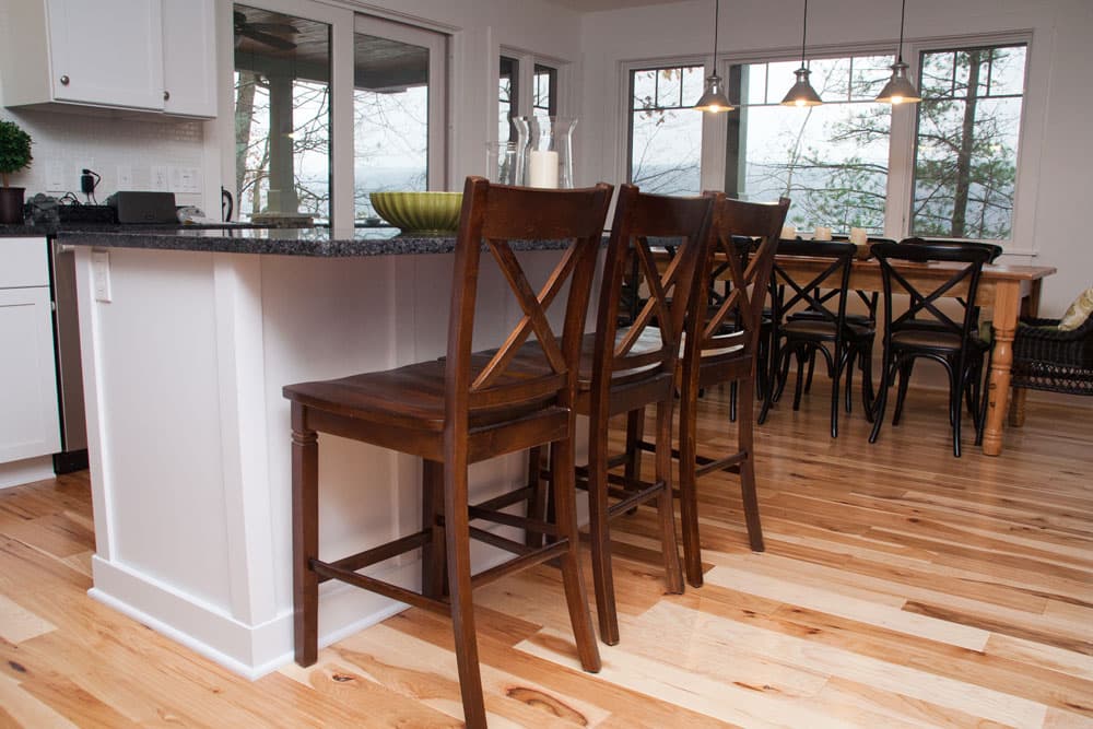 Open kitchen with island bar seating and dining area overlooking waterfront