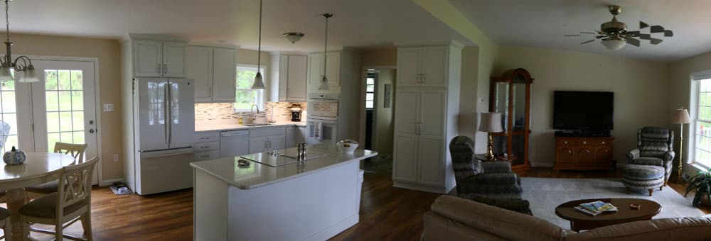 Open concept kitchen and living room with white cabinets, island, and hardwood floors