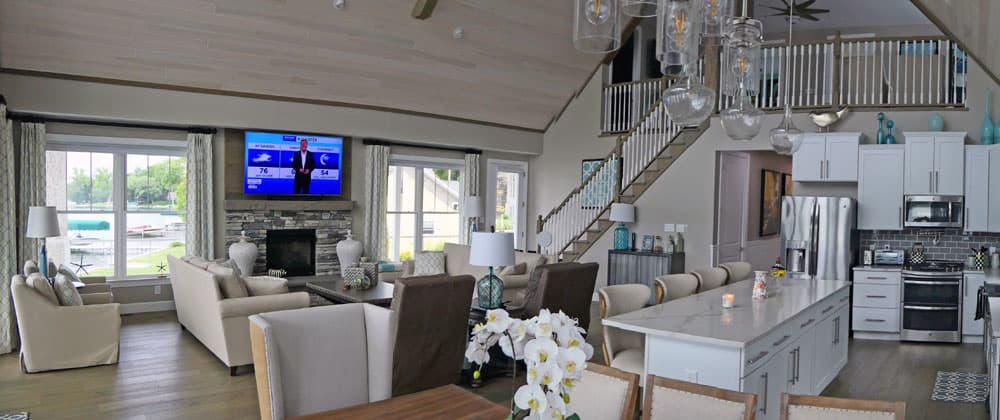 Open concept living room and kitchen with vaulted ceiling and staircase